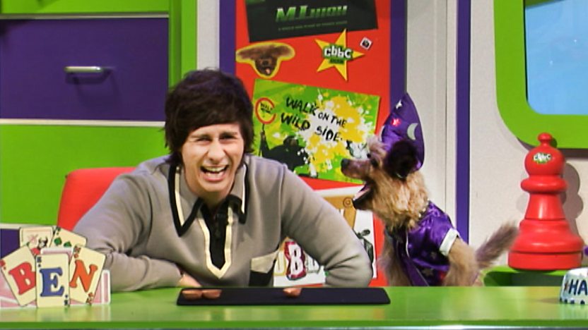 Hacker T Dog and Ben Hanlin laughing in the CBBC Office, hacker is wearing a wizards outfit.