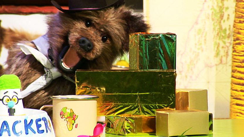 Hacker T Dog smiling next to a pile of gold bars