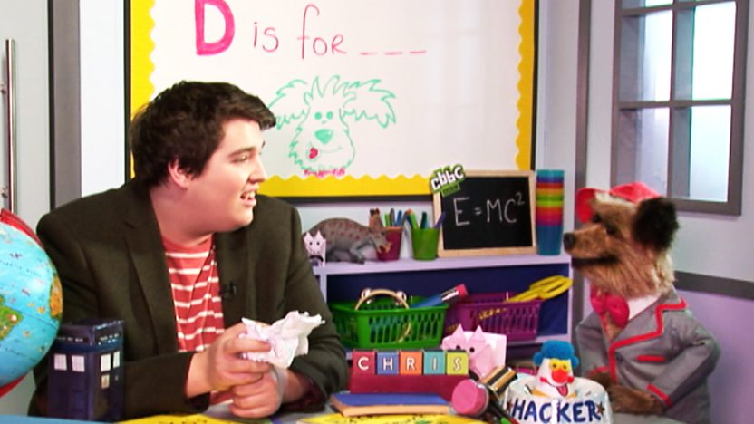Hacker T Dog and CBBC Presenter Chris Johnson in a classroom.