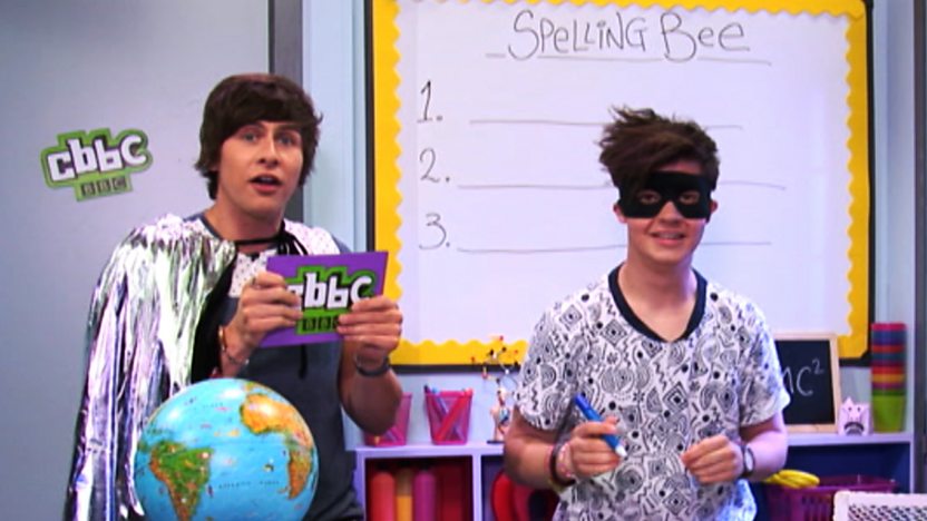 Ben and Cel in the CBBC Office classroom, Ben is wearing a silver cape and Cel is wearing a Zorro style mask.