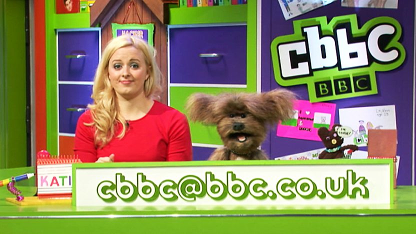 Dodge T Dog and Katie Thistleton in the CBBC Office with the CBBC Email: cbbc@bbc.co.uk in front of them.