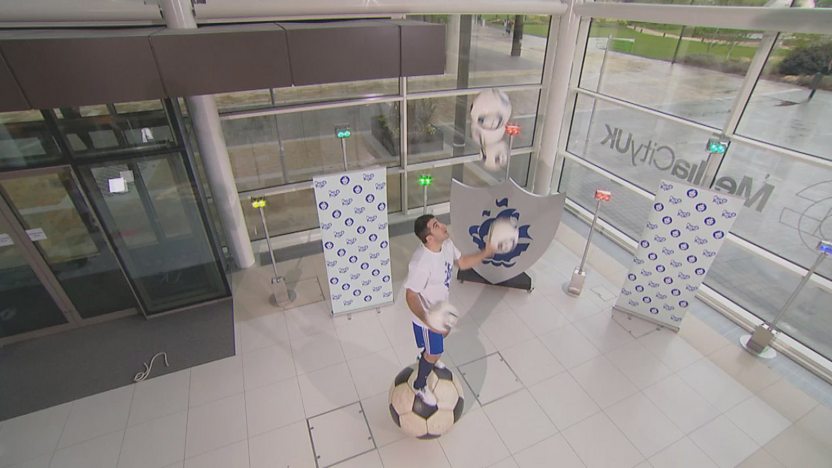 Juggling genius juggling footballs on a giant football