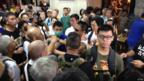 「佔領中環」運動削髮儀式會場內數名戴上手術口罩和墨鏡的示威者（中）與志願者推搡（香港電台圖片9/9/2014）