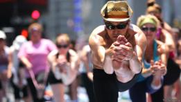 Hombres y mujeres practicando Bikram o hot yoga en las calles de Nueva York