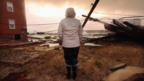 A woman surveys damage in the aftermath of Hurricane Sandy.