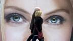 People walking in front of eyes on billboard (AFP/Getty)