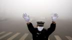 Directing traffic in smoggy downtown Beijing (AFP)