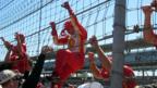 Driver Helio Castroneves climbs the netting at Indy in 2013. (Credit: Rebecca Falik)