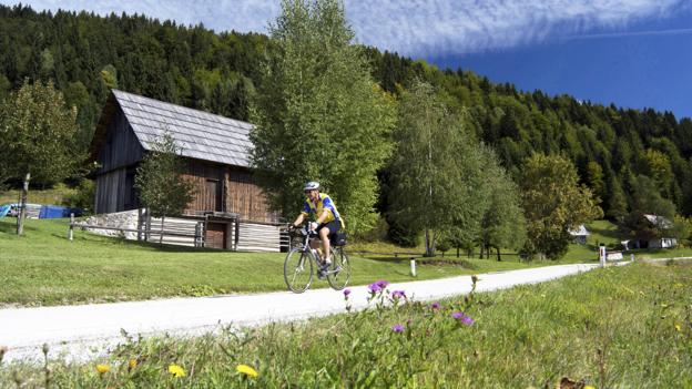 A single cyclist rides Bohinj's quiet country roads (Credit: Credit: Rebecca E Marvil/Getty)