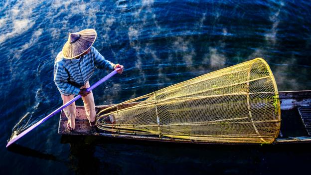 The fishermen travel in small canoe-like motorless boats (Credit: Credit: Blend Images/Alamy)