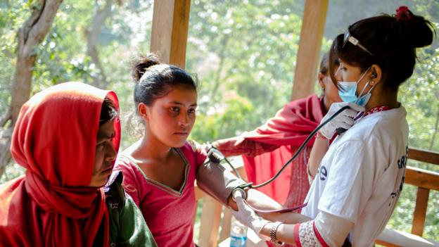 A volunteer doctor treats an earthquake survivor at a makeshift clinic 