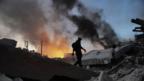 Man walks past flames in the aftermath of the Haiti Earthquake (Copyright: Getty Images)