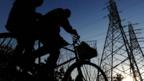 Cyclists in China pass electricity pylons (Copyright: Getty Images)