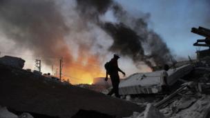 Man walks past flames in the aftermath of the Haiti Earthquake (Copyright: Getty Images)