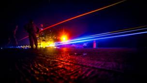 Lights shine across the deck of a warship (Copyright: US Navy)