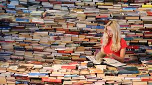 Woman looks at a book in the aMAZEme labyrinth, London (Copyright:Getty Images)
