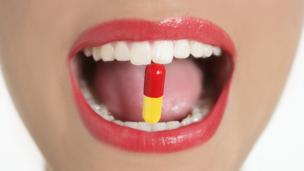 Woman with a pill in her mouth (Copyright: Thinkstock)