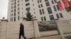 Man walks past building identified by Mandiant as the likely source of cyber attacks