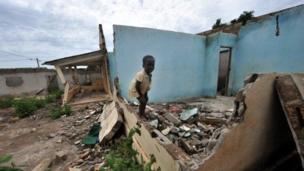 A child plays in the ruins of a house destroyed during the massacre at Duekoue, April 2012