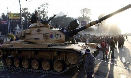 Egyptians walk past army tanks deployed near the presidential palace 6/12/12