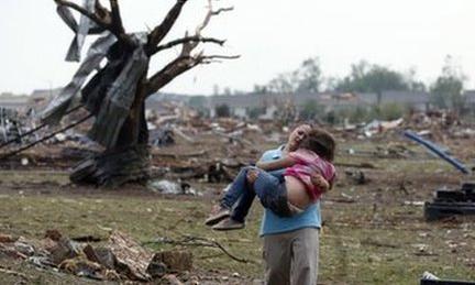A woman carries a child after the tornado in Moore, Oklahoma (20 May)