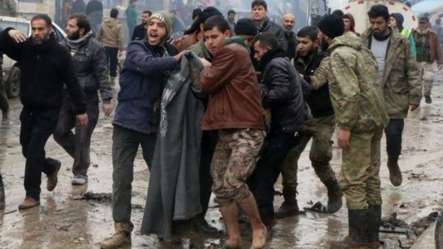 Rescue workers attend to the wreckage after they and Syria's opposition activists say dozens were killed when a car bomb went off in a busy market in a rebel-held Syrian town of Azaz along the Turkish border, Saturday, Jan. 7, 2017