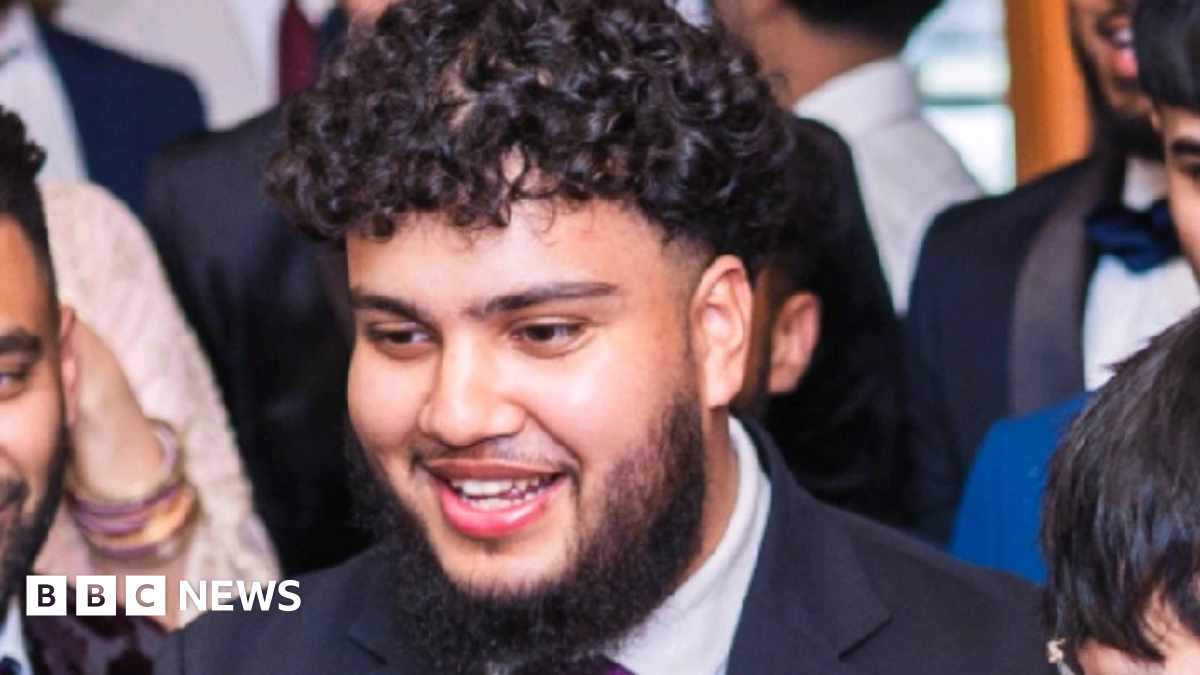 Alvi Choudhury is wearing a suit and has dark short curly hair and a dark full beard