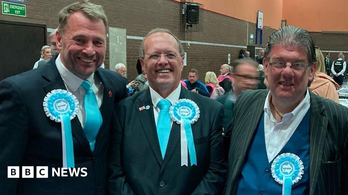 Stephen Atkinson, Ian Duxbury and Ged Mirfin at the Lancashire County Council count. All are wearing turquoise reform rosettes