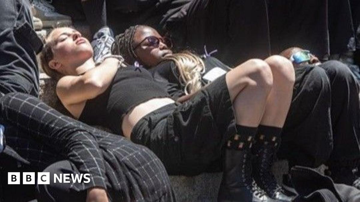 Students, dressed in black, are seen lying down as they take part in a silent protest in South Africa