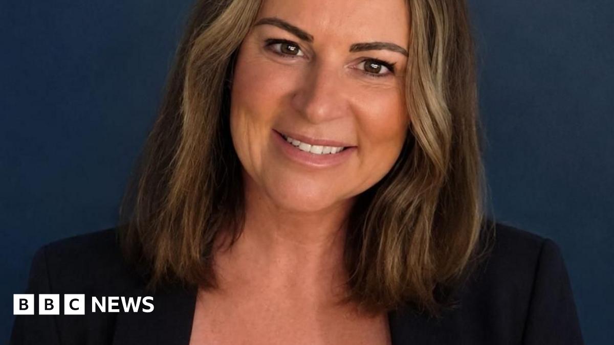 Restore Britain candidate, Rebecca Shepherd. She has shoulder-length dark hair, is wearing a dark blazer and a white blouse. 