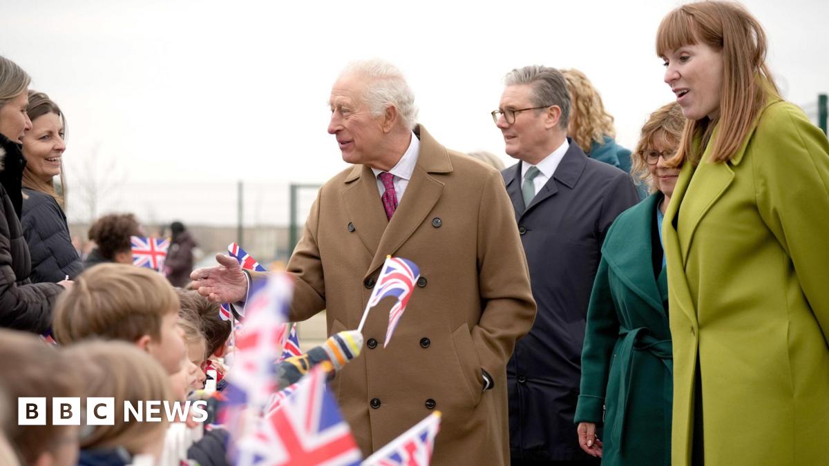 The King, Prime Minister and Deputy Prime Minister on a visit together in Cornwall - children are waving Union flags and the trio are smiling and speaking with the crowd
