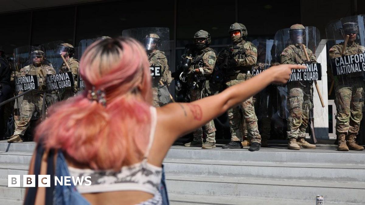 A protestor with pink hair points at guards as they confront the California National Guard as they protect the Federal Building during protests sparked by immigration raids in Los Angeles, California, USA, on 9 June 2025.