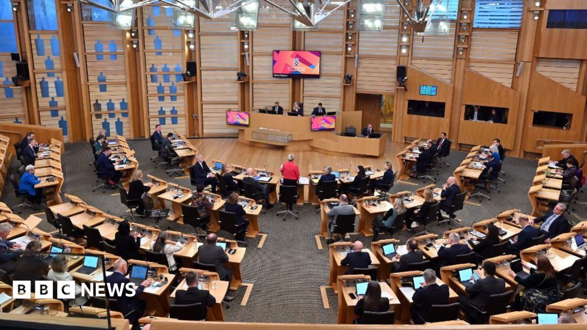 A general view of the Scottish Parliament chamber, with MSPs sitting at wooden desks 