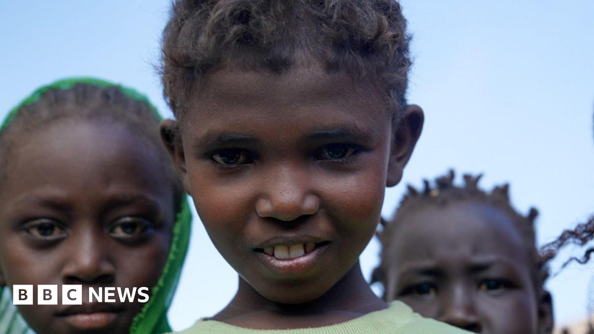 Three children in Sudan stare directly at the camera