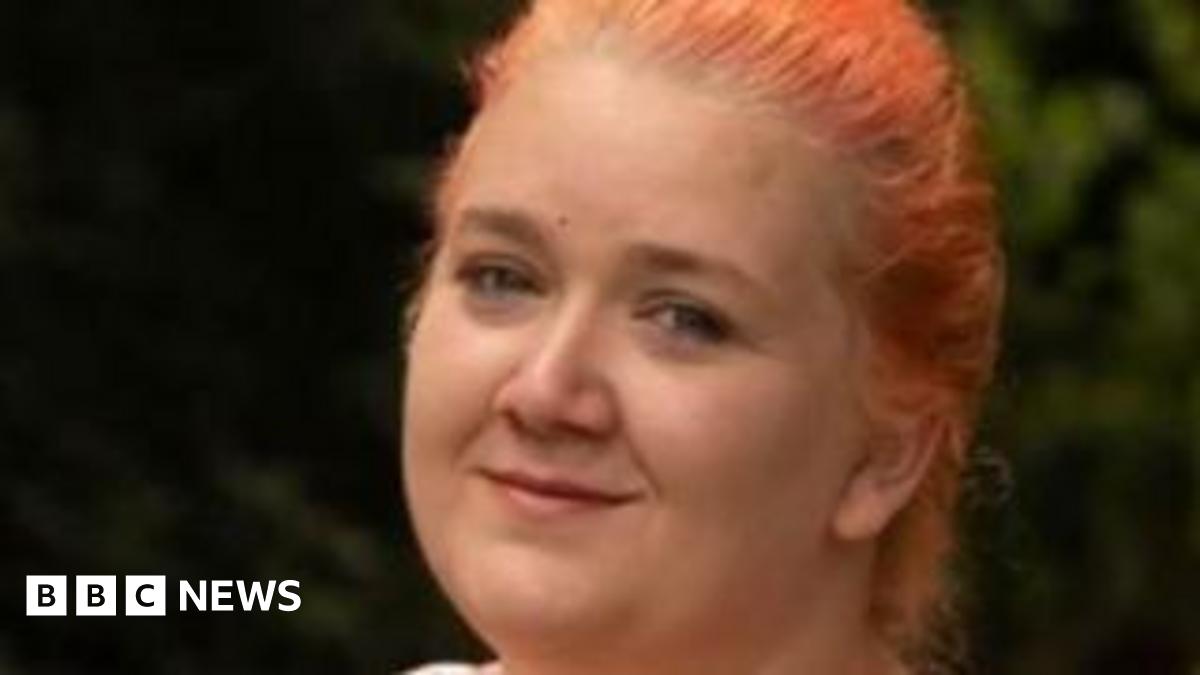 Rhiannon with ginger hair in a plait smiling at the camera