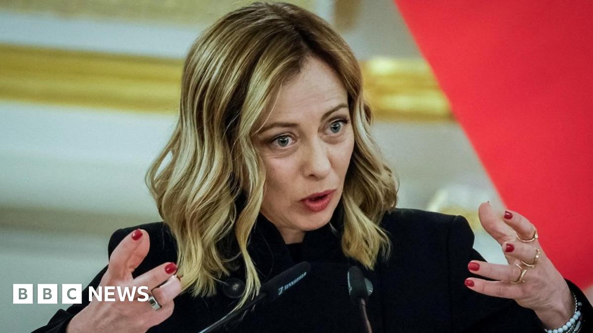 Giorgia Meloni at a podium prepared for battle