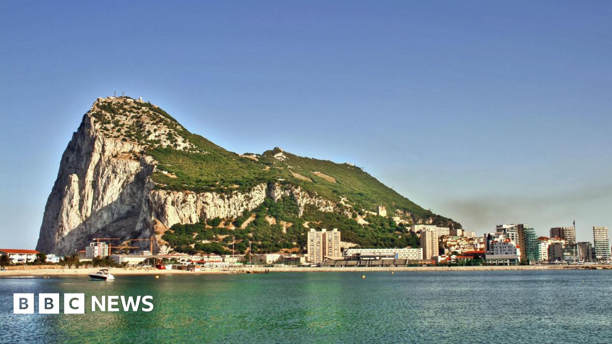 A wide shot of the rock of Gibraltar with the sea in the foreground.