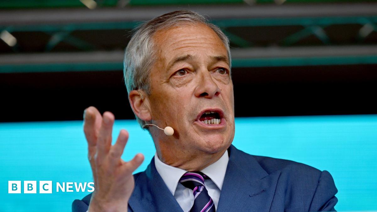 Nigel Farage stood at a lectern with one hand gesturing to his left.