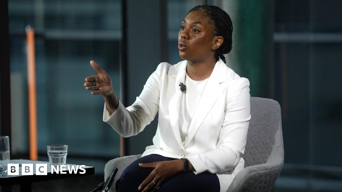 Kemi Badenoch wearing a white jacket and t-shirt