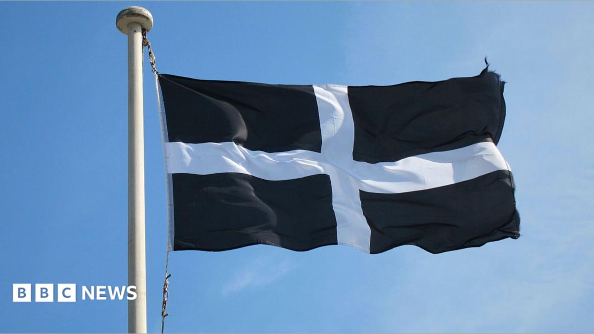 The St Piran's flag - the flag of Cornwall - with a dark blue background and white cross, is seen blowing in the wind 