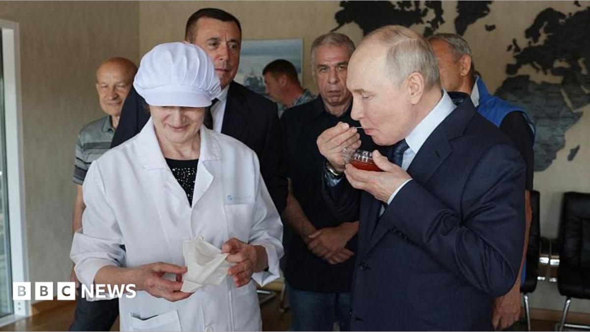 Russia's President Vladimir Putin tastes caviar as he visits the Yasny fish processing factory on Iturup, known in Japan as