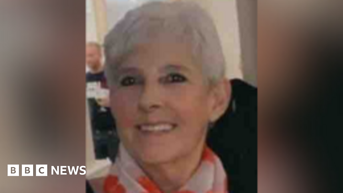 Image of Marie Casey. She is 63, with short grey hair. She is smiling and wearing a scarf.