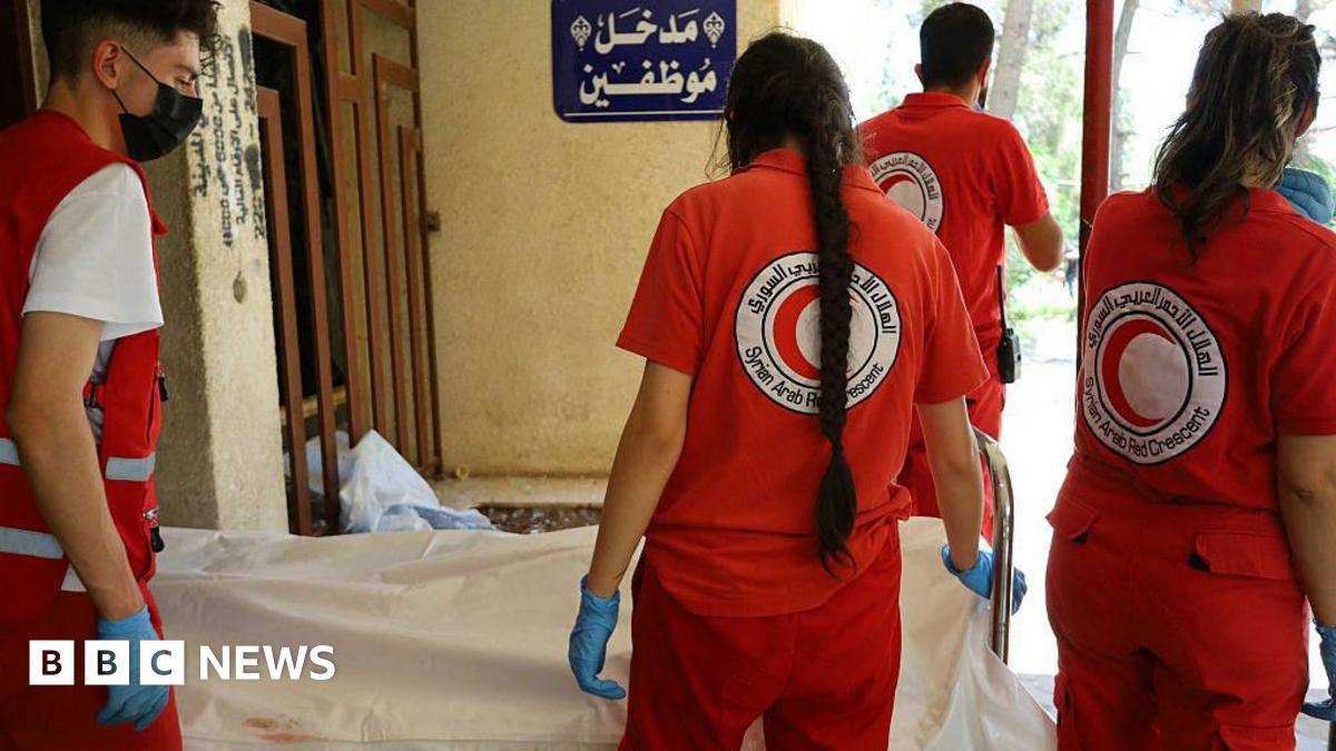 Syrian Red Crescent rescuers stand next to the body of a victim of the recent clashes in Suweida province, at a hospital in Suweida city (17 July 2025)