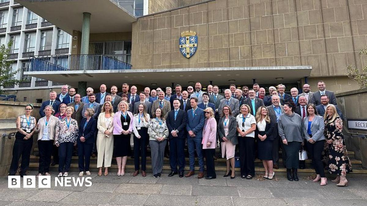 A large group of male and female councillors outside Durham County Council's county hall
