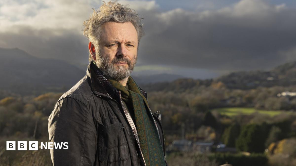 Photo: bbc.co.uk Standing on high ground above a valley, Michael Sheen looks towards the camera with rolling hills and patchwork fields