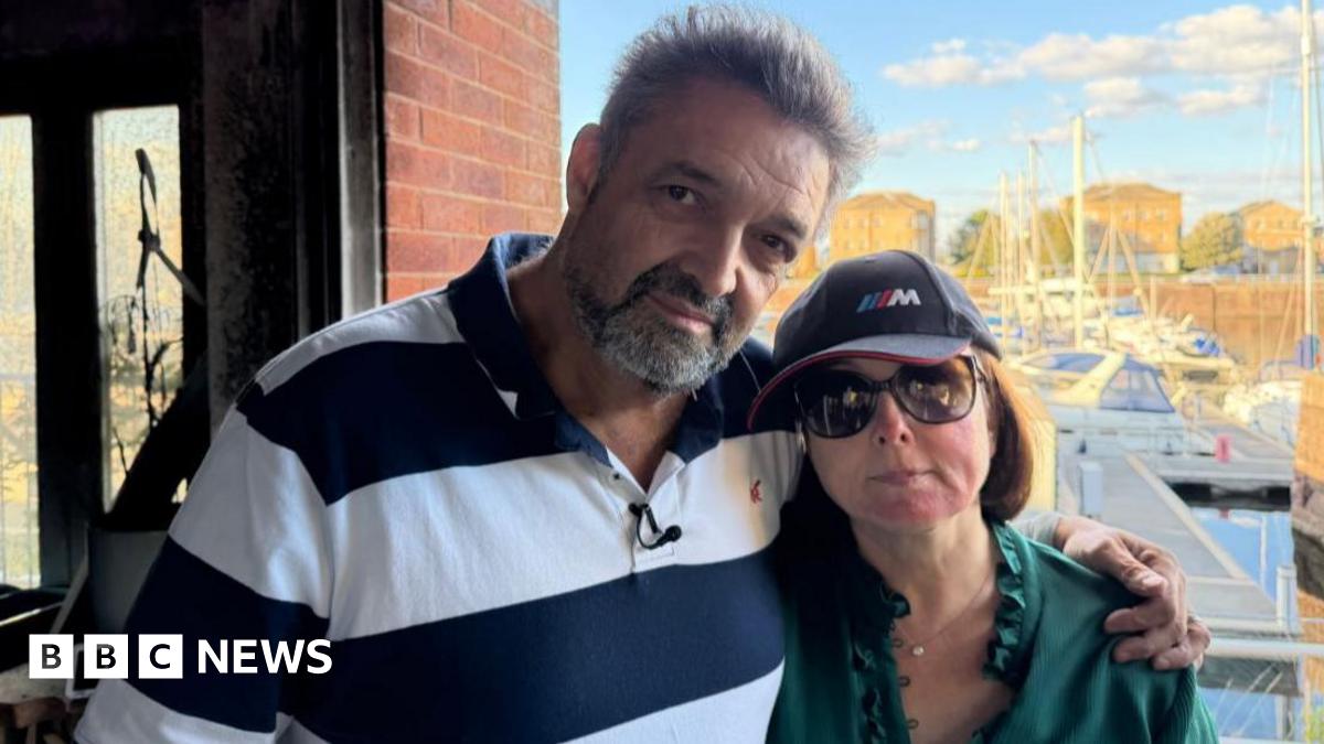 Nick and Angela Palit stand outside their fire-devastated home