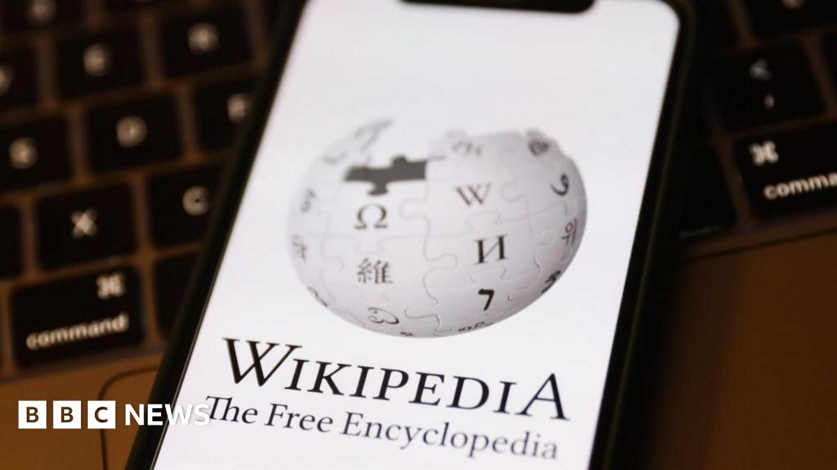 Wikipedia logo on a phone screen. The logo is a globe made out of puzzle pieces. On each puzzle piece is a letter of the alphabet taken from a different language's alphabet - for example, there are Greek, Arabic and Cyrillic characters visible as well...