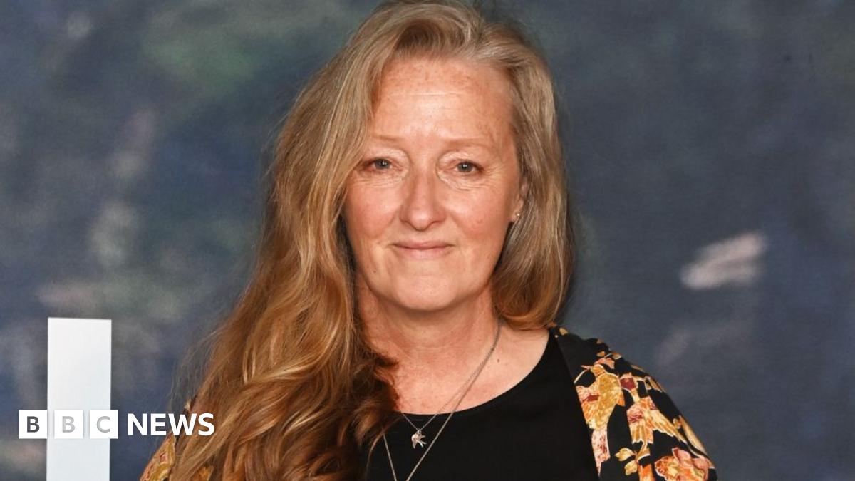 Raynor Winn attends the UK Special Screening of The Salt Path at The Curzon Soho on 22 May 2025 in London. She has long strawberry blonde hair and is wearing a black and yellow top.