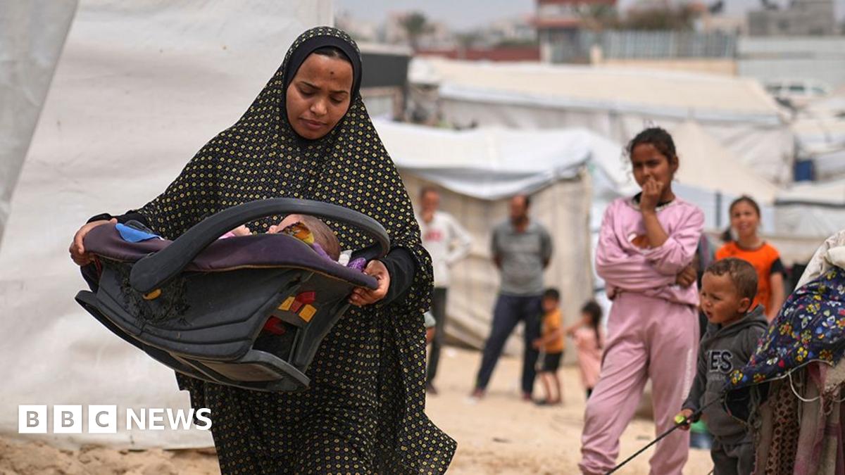 Shaima al-Louh, 24, carries her three-month-old daughter, Jilan Zarrouk, at a makeshift tent camp for displaced Palestinians in al-Mawasi, on the outskirts of Khan Younis in the southern Gaza Strip (9 April 2025)
