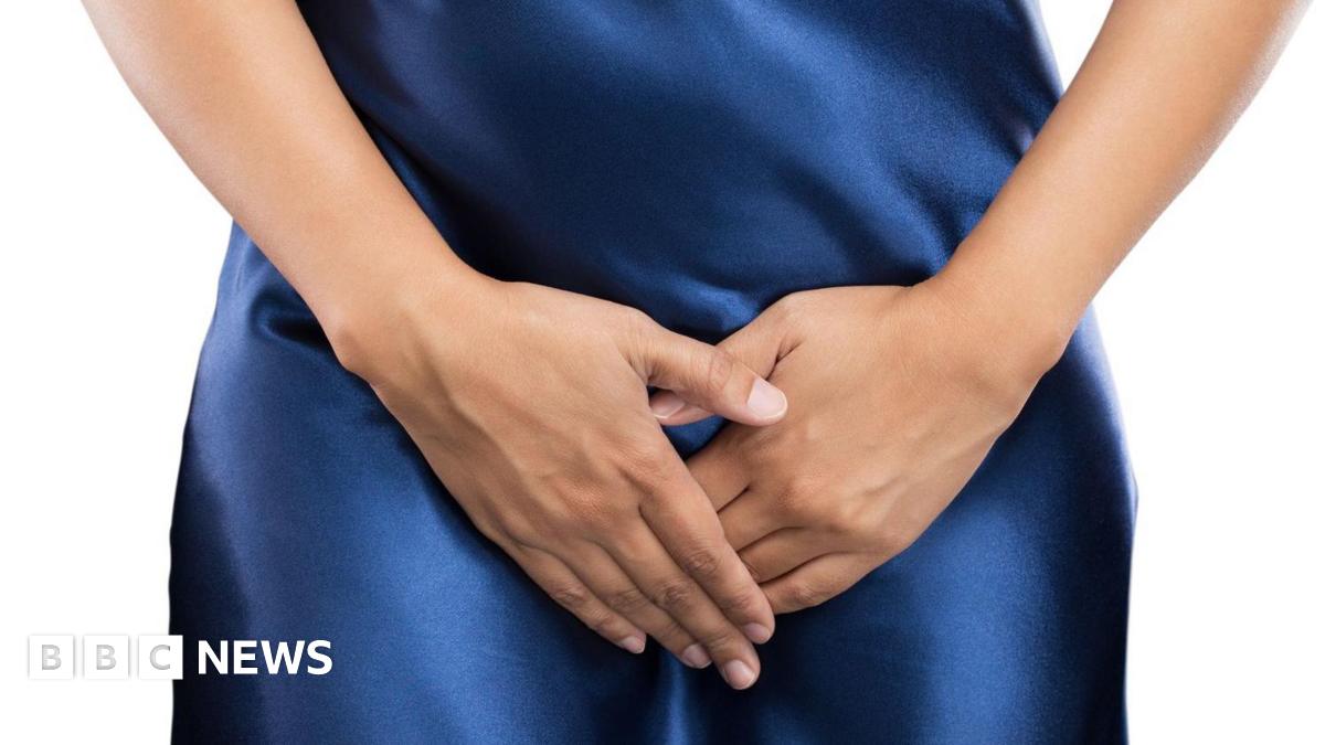 A anonymous woman stands with her hands shielding her pubic area